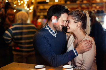 Happy couple kissing at bar and having date