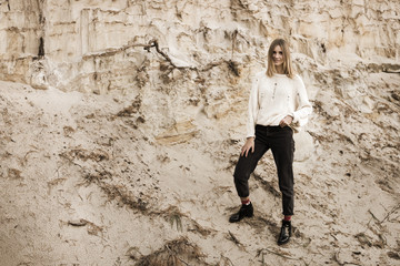 Toned portrait of a smiling woman standing among a sand pit