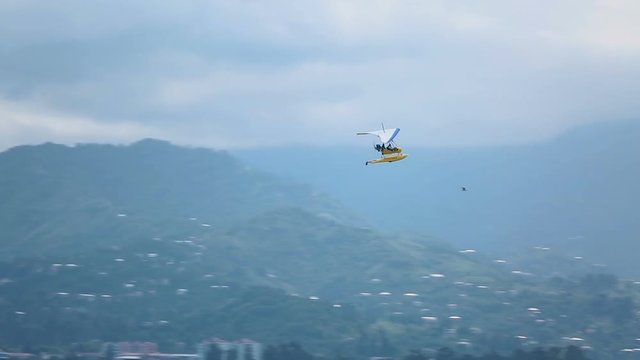 Hang-glider flying high in the sky and landing at seaside, active tourism, sport