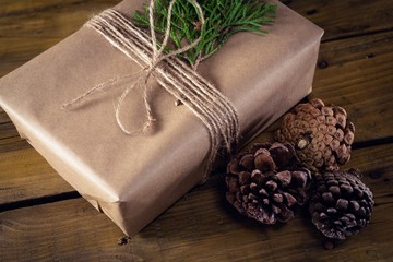 Fototapeta na wymiar Gift box, fir and pine cone on wooden table