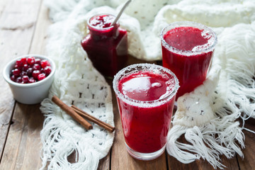 Cranberry juice in glasses on a wooden background with spruce branches. - 183931082