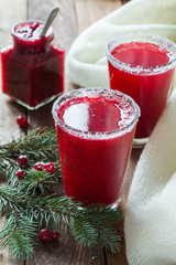 Cranberry juice in glasses on a wooden background with spruce branches. - 183931221