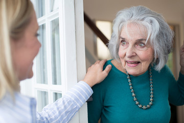 Woman Checking On Elderly Female Neighbor