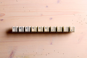 Trends 2018 concept on computer keyboard keys buttons on a wooden background