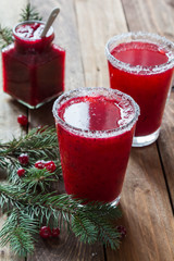 Cranberry juice in glasses on a wooden background with spruce branches. - 183933438