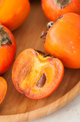 Plate of fresh and ripe persimmons. Close up.