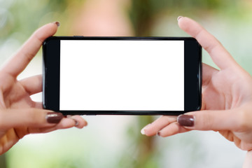 Close up of woman using mobile smart phone,sending massages on the garden.having sunbath.Phone with black screen,texting,video calls,