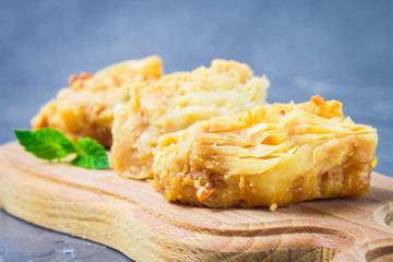 baklava turkish traditional delight on a dark wood background. toning.