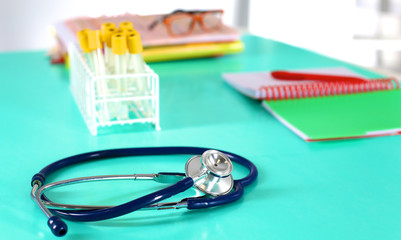 Doctor's workspace working table with patient's discharge blank paper form, medical prescription, stethoscope on desk