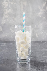 Glass with sugar cubes is an unhealthy diet. The contents of sugar in sweet soda.