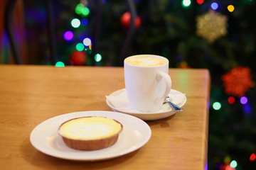 coffee Cup and cake on the table near the Christmas tree