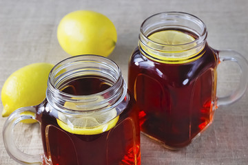 Black or herbal tea with lemon on a old wooden background.