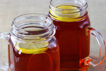 Black or herbal tea with lemon on a old wooden background.