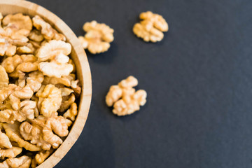 Whole Walnuts and Cleared Black Wooden Background Top view Healthy concept. Natural light. Selective focus. Close up on a black background. Top view, flat lay. copy space.
