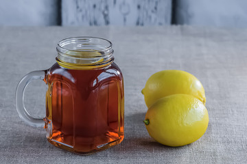 Black or herbal tea with lemon on a old wooden background.