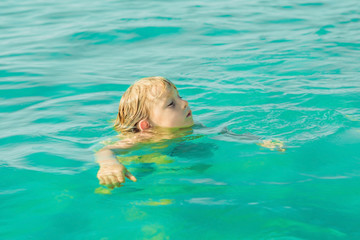 boy swims in the blue tropical sea. hot summer