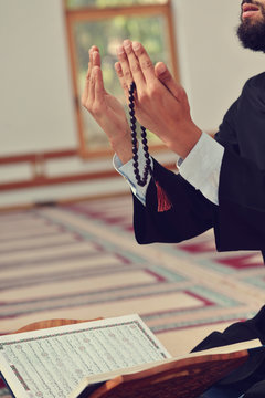 Hand of muslim people praying with mosque interior background