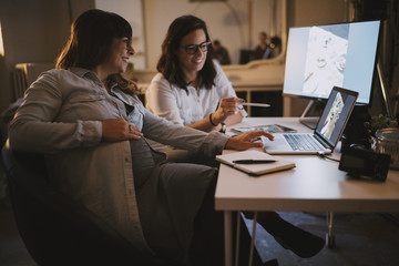 Pregnant woman working in her studio with a colleague