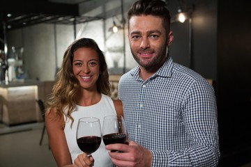 Portrait of happy couple holding red wine