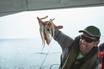 Fisherman holding octopus