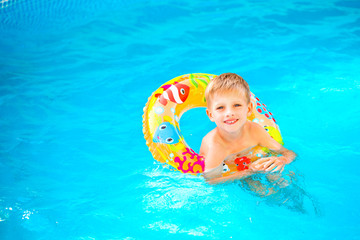 Boy floating on an inflatable circle in the pool