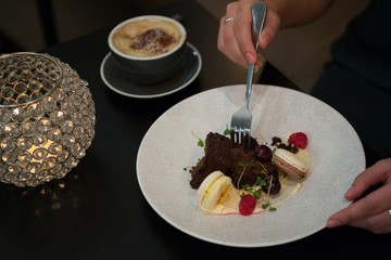 Woman having dessert and coffee at table