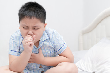 Sick obese boy is coughing and throat infection