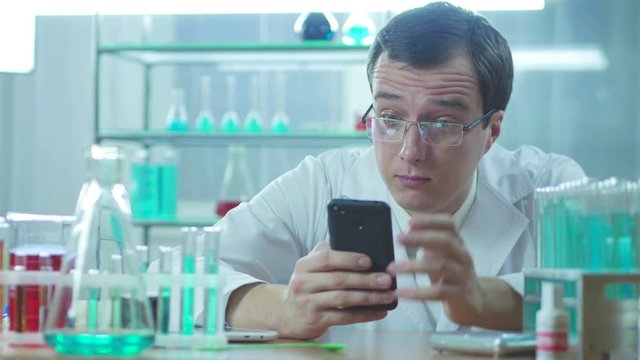 Doctor looks at mobile phone and working in laboratory. 