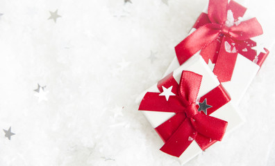 white gift box with a red bow on the snow