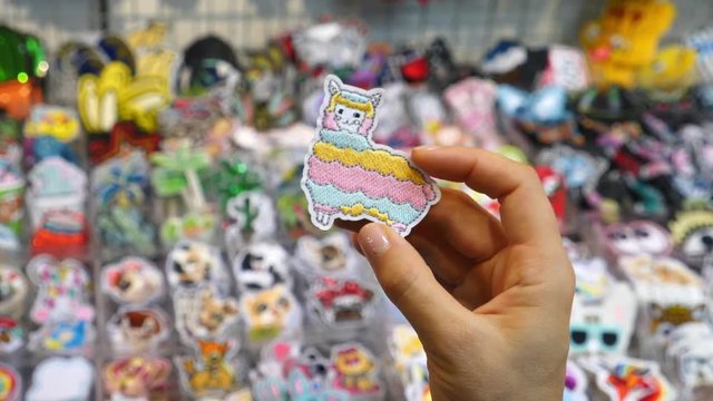 Close Up Of Fashion Lama Patch In Hand At Market. 4K. 