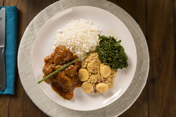 Delicious healthy food with cooked meat and banana's flour and rice on the plate. View from the top.