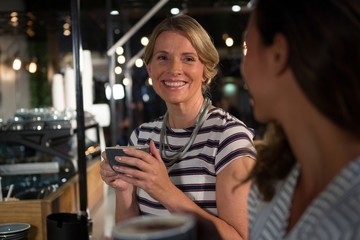 Happy woman interacting while having coffee