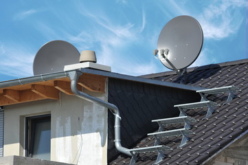 Satelliten-Antenne, Schornstein, Dachtreppe und Gaube auf einem Rohbau-Dach mit offener Balkendecke