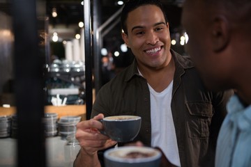 Happy man interacting while having coffee