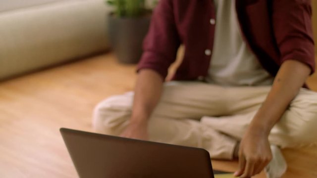 man with laptop shopping online at new home