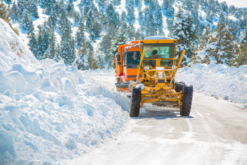 The bulldozer cleans snow on road