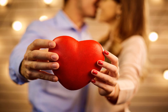 Heart In The Hands Of A Young Couple Close-up. Concept Valentine's Day.