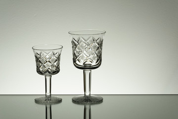 Crystal glass illuminated on mirror and black background