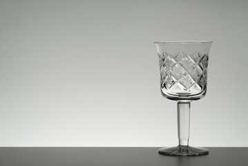 Crystal glass illuminated on mirror and black background