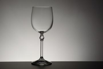 Crystal glass illuminated on mirror and black background