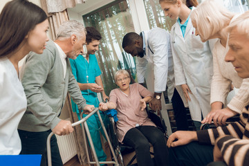 The doctor is talking to an elderly woman in a nursing home.