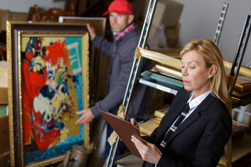 auctioneer and assistant rchecking auction goods