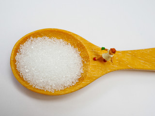 Miniature little child standing on a wooden spoon and thinking of sugar, diet, fat and diabetes. Health care concept.