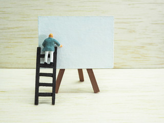 Miniature businessman with blackboard, worried about economic and finance during covid-19 outbreak....