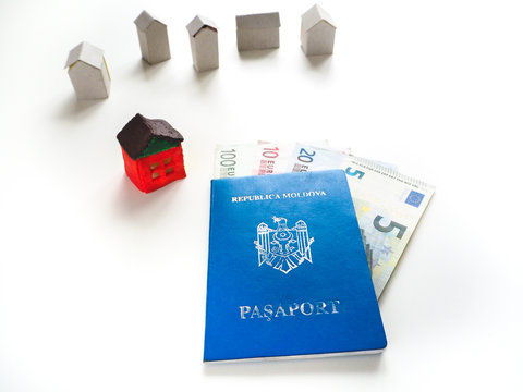 Moldovan passport, euros and a small toy house. The concept of emigration.