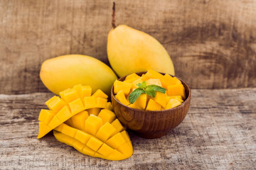 Mango fruit and mango cubes on the wooden table