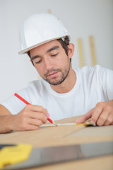 man measuring a plank