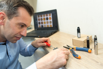 man fixing electronic circuits in service center