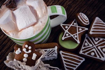 Various cookies and hot chocolate on wooden plank