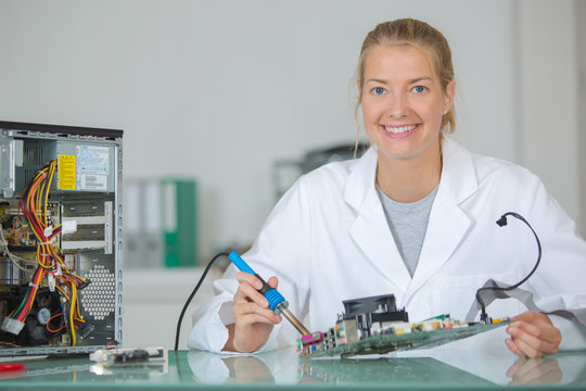 Female computer technician using soldering iron